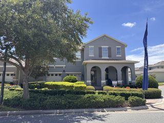 A charming gray home with arches and lush landscaping in Waterleigh by D.R. Horton (Winter Garden, FL).