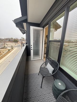 A cozy balcony with modern decor and seating, perfect for relaxation.
