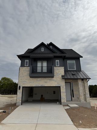 A modern stone and wood home with a sleek design in Foxfield by Milestone Community Builders (Austin, TX).