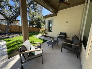 A cozy patio with modern seating, nestled in a serene backyard, ideal for relaxation and outdoor enjoyment.