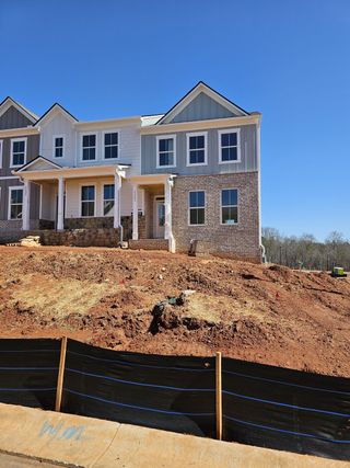 A modern two-story townhome with brick and siding facade in Waypoint by D.R. Horton (Flowery Branch, GA).