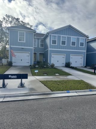 Street view A charming blue duplex with white trims and tidy landscaping in Sadler Trace by Ryan Homes (Jacksonville, FL).