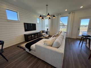 A cozy living room with a shiplap accent wall, large windows, and a bright, airy feel.