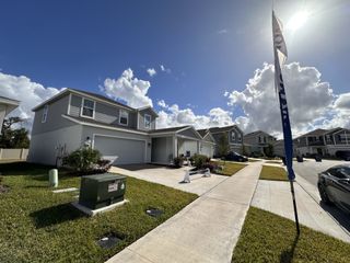 A charming two-story home with a manicured lawn in Ranches at Lake McLeod: Manor Key Collection by Lennar (Eagle Lake, FL).