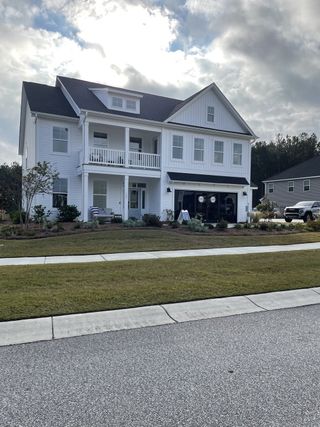A charming white home with a welcoming porch in Lochton by Mungo Homes, Summerville, SC.