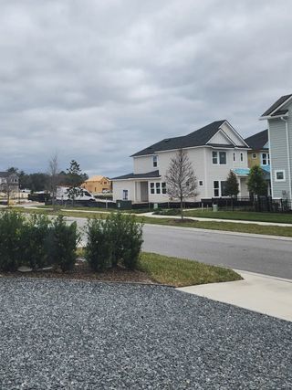 A street view in Granville at eTown by David Weekley Homes (Jacksonville, FL) shows modern two-story homes with siding under a cloudy sky.