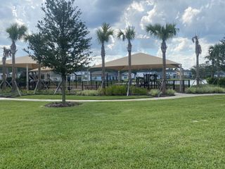 A charming community park with palm trees and shade structures in Reflections At Nocatee by Riverside Homes (Ponte Vedra Beach, FL).
