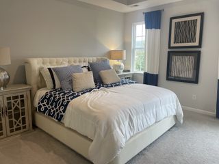 A cozy bedroom with an upholstered bed, soft lighting, and elegant decor, featuring blue and white accents for a tranquil feel.