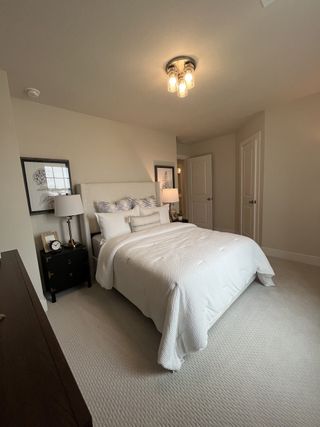 Model Home A beautifully decorated bedroom with soft pink bedding, rattan headboard, and large window for natural light.