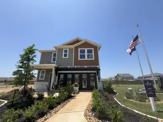 Street view A modern model home with a landscaped front yard in Hacienda by Century Communities (San Antonio, TX).