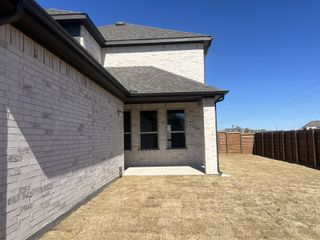 A beautiful white brick home with a fenced yard and spacious patio in Solterra by HistoryMaker Homes (Mesquite, TX).