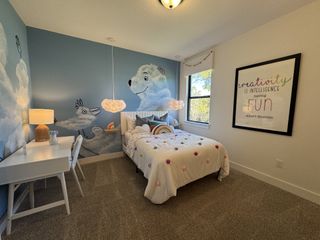 A playful children's room with a cloud-themed mural, cozy bed, and a study desk, perfect for inspiring creativity.