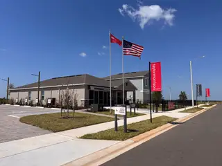 Street view A modern model home with sleek design and manicured landscaping in Scenic Terrace by Taylor Morrison (Lake Hamilton, FL).