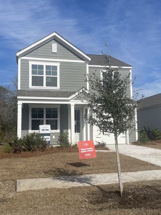 A charming grey home with a welcoming porch and fresh landscaping in Sheep Island by D.R. Horton (Summerville, SC).