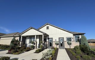 Street view A charming single-story home with a manicured lawn in Talavera by D.R. Horton (Kyle, TX).