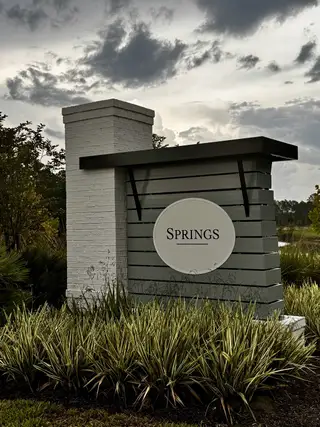 Community Amenities A welcoming entrance sign surrounded by greenery at RiverTown - Springs by Mattamy Homes in St. Johns, FL.