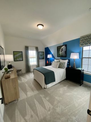 A vibrant bedroom with bold blue walls, soccer-themed decor, and cozy furnishings, perfect for a sports enthusiast.