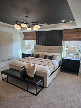 A chic bedroom with a plush bed, stylish lighting, and modern decor elements, radiating comfort and elegance.