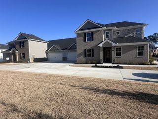 A beautiful two-story brick home with a spacious driveway in Independence by D.R. Horton (Loganville, GA).
