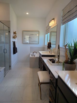 A sophisticated bathroom with a glass shower, dual vanity, and elegant decor, offering both style and functionality.