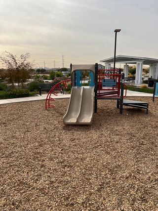 A charming playground with slides and climbing equipment in Highland Ridge at Alamar by Brookfield Residential (Avondale, AZ).