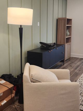 A cozy seating area with a sleek floor lamp, modern cabinetry, and inviting decor for a comfortable living space.