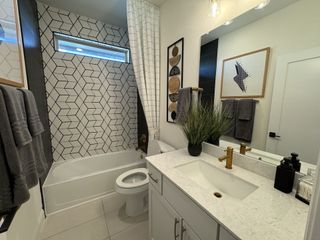 A modern bathroom with geometric tile, sleek fixtures, and stylish decor.