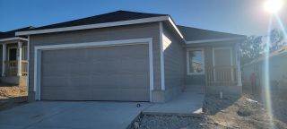 Street view A modern grey home with a spacious garage in Torian Village: Watermill Collection by Lennar (San Antonio, TX).