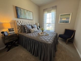 A cozy bedroom featuring a tufted headboard, elegant decor, and soft lighting, creating a tranquil atmosphere.