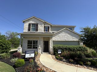 Street view A beautiful stone facade home with lush landscaping in Blue Ridge Ranch by M/I Homes (San Antonio, TX).