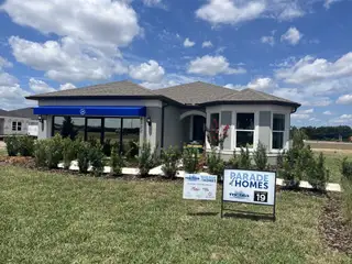 Street view A modern model home with lush landscaping and a sleek facade in Marion Ranch by Pulte Homes (Ocala, FL).