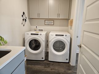 Model Home A functional laundry room with front-load washers, cabinetry, and modern decor in Oak Ridge Meadows by D.R. Horton (Locust Grove, GA).