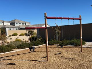 A serene playground with swings and desert landscaping in Zanjero Pass by D.R. Horton (Waddell, AZ).