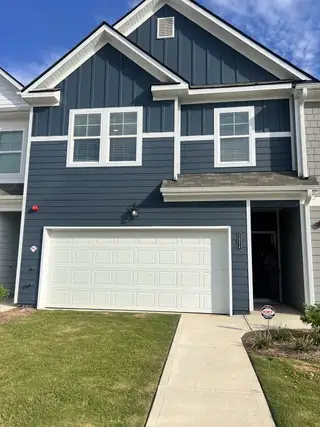 Charming blue and gray townhouse with white trim in The Retreat at Walden Park by Rockhaven Homes (Jonesboro, GA).