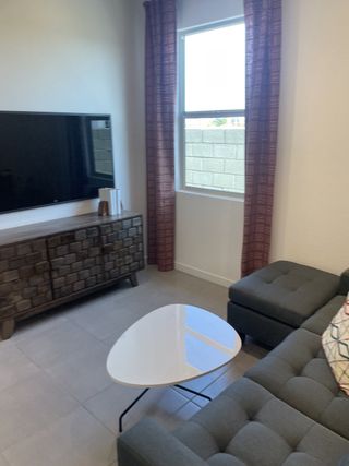 A cozy living room with a modern gray sectional, sleek TV, and chic coffee table paired with contemporary accents.