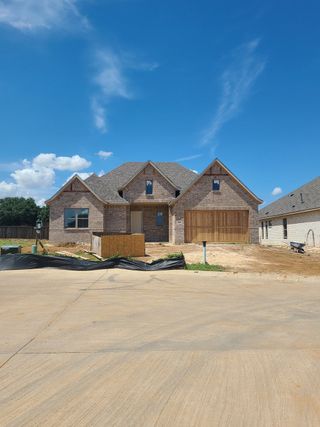 A charming brick home under clear skies in Riverdance by West Point Homes (Keller, TX).