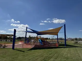 Family-friendly playground with shade sails in The Hills at Avery Centre by Century Communities (Round Rock, TX).