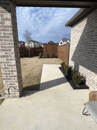 Model Home A quaint backyard with a patio and manicured lawn, offering a cozy outdoor space.