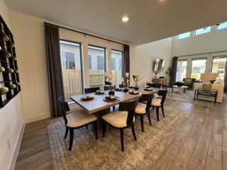 A spacious dining and living area with elegant furnishings, large windows, and stylish decor.