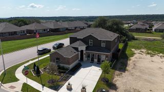 Street view A modern brick home with a spacious yard at Lively Ranch: Brookstone Collection by Lennar (Georgetown, TX).