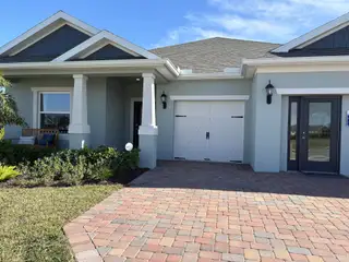 A charming home with columns and a manicured lawn in Spirit Of Sebastian by Holiday Builders (Sebastian, FL).