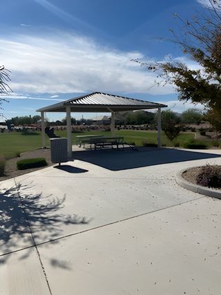 A spacious community area with a picnic shelter and lush lawn at Artisan at Asante by Taylor Morrison (Surprise, AZ).