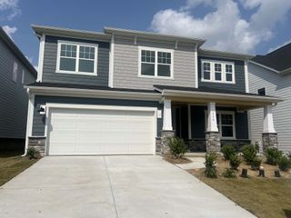 A modern two-story home with elegant stone accents and a spacious garage in Adair Woods by D.R. Horton (Davidson, NC).