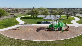 A scenic playground and green park area in Mustang Valley by KB Home, Manor, TX.
