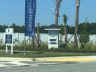 A welcoming entrance to Atlantis Pointe by Dream Finders Homes, surrounded by lush greenery in Middleburg, FL.