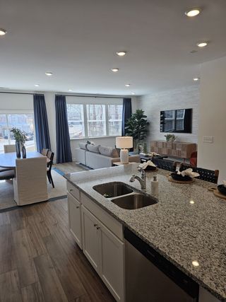 Open-concept kitchen and living area with granite countertops, cozy seating, and abundant natural light.