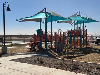 Community Amenities A vibrant playground with azure shades and slides in Rancho Mirage Signature Series by Meritage Homes (Maricopa, AZ).