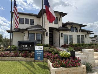 Street view A stunning white brick home with elegant landscaping in Sienna 55' - Valencia by Perry Homes (Missouri City, TX).