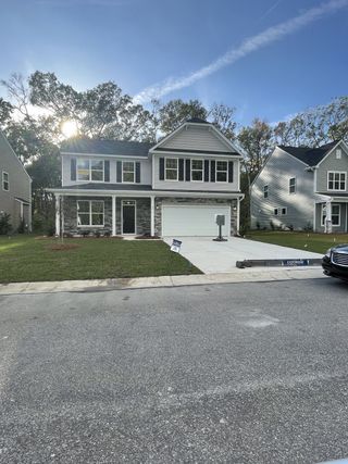 A lovely two-story, stone-accented home with a spacious driveway in Magnolia Pointe by Eastwood Homes (North Charleston, SC).