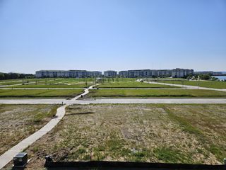 Street view Expansive green spaces with modern, multi-story buildings in Bayside by Beazer Homes (Rowlett, TX).